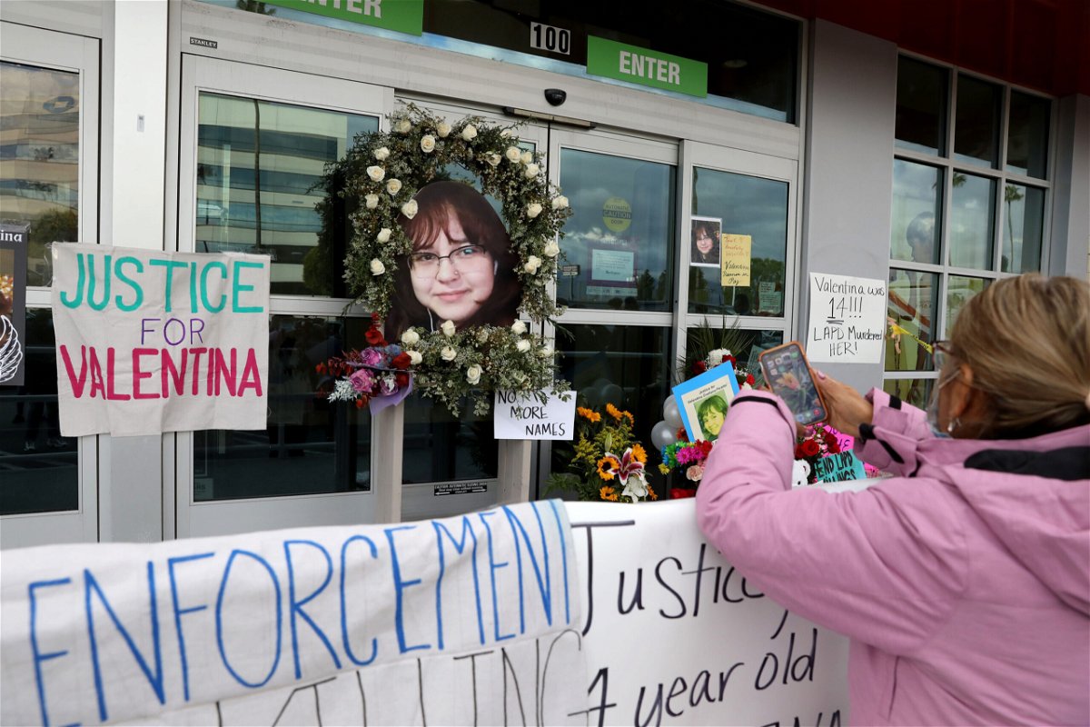 <i>Gary Coronado/Los Angeles Times//Shutterstock</i><br/>A woman stands at a memorial for Valentina Orellana-Peralta at the door of the Burlington where she was killed