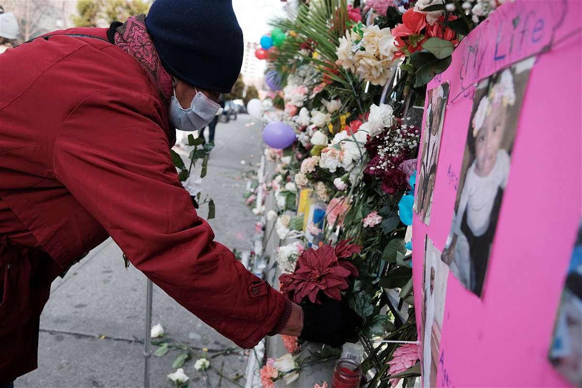 <i>Spencer Platt/Getty Images</i><br/>People visit a memorial set up for the victims outside the apartment building where a five-alarm fire took place on January 14