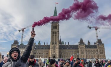 A man yells while holding a smoke firework during a protest against a Covid-19 vaccine mandate on Parliament Hill in Ottawa on Saturday.