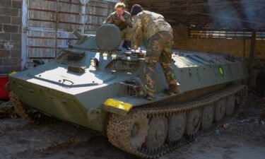Soldiers from Ukraine's Territorial Defense Forces inspect a Russian armored personnel carrier they captured on the battlefield.