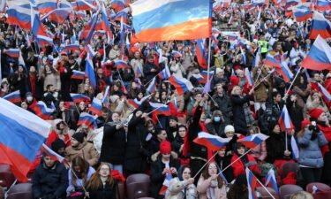 Russians hold flags and cheer during the concert that featured live music and speeches from high-profile Putin supporters.