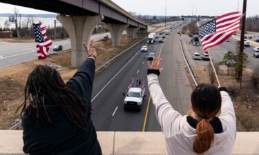 Supporters wave as a convoy of trucks and other vehicles travel I-495 near the Woodrow Wilson Bridge