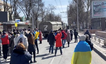 Demonstrators chant "go home" while Russian military vehicles reverse course on a road in Kherson on March 20.