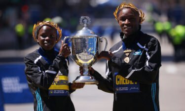 Kenya's Evans Chebet (R) and Peres Jepchirchir celebrate with the Boston Marathon trophy after winning the elite men's and women's races.
