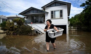 Patria Powell walks through floodwater after salvaging items from her mother's flood-affected home March 07