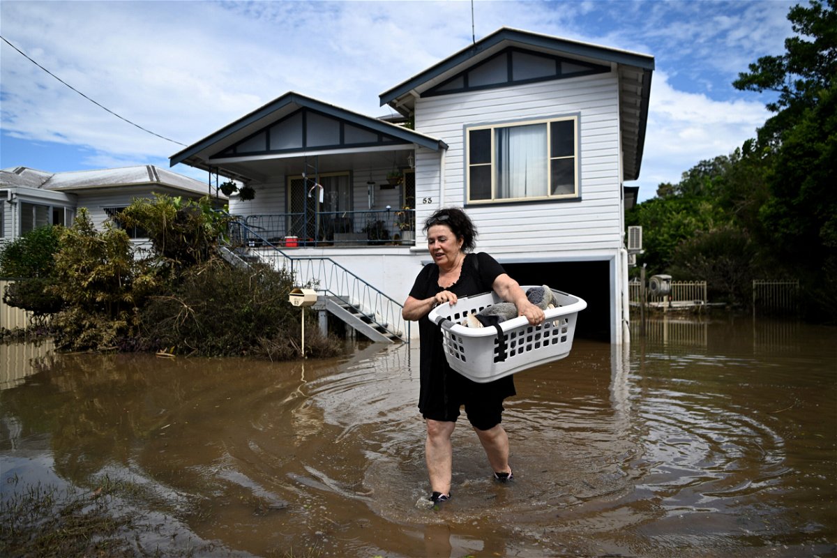 <i>Dan Peled/Getty Images</i><br/>Patria Powell walks through floodwater after salvaging items from her mother's flood-affected home March 07