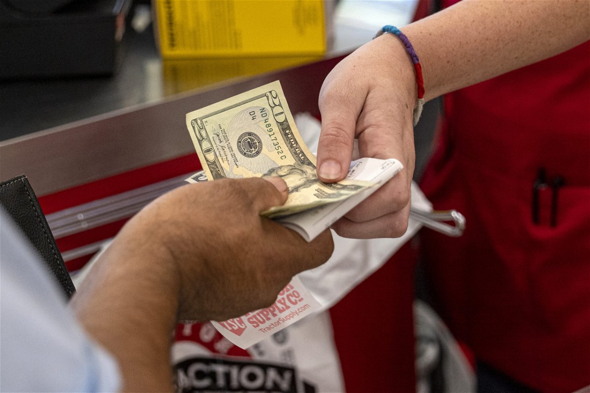 <i>David Paul Morris/Bloomberg/Getty Images</i><br/>A customer pays cash for a purchase at a store in Merced