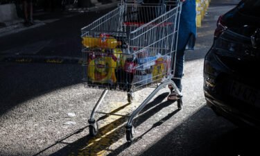 A customer pushes a shopping cart in the parking lot of the Carrefour SA hypermarket in Marseille