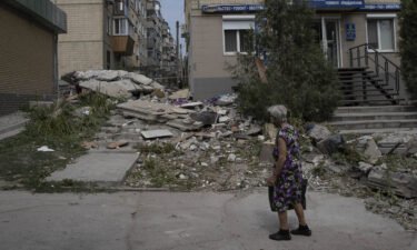A woman assesses the damage on a street in Nikopol