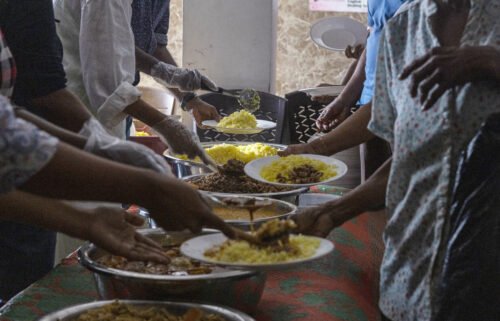 Volunteers serve free meals to people in need at a community kitchen in Colombo