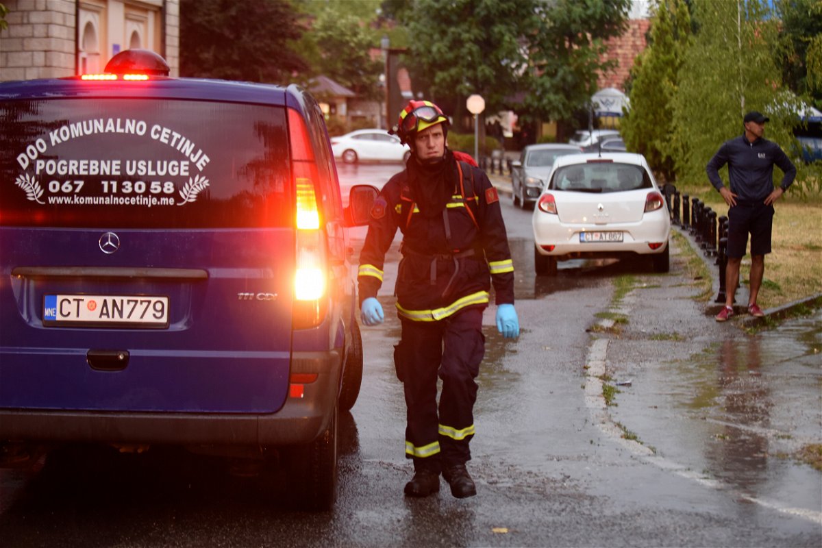 <i>Risto Bozovic/AP</i><br/>A firefighter walks by a hearse on the site of the attack in Cetinje