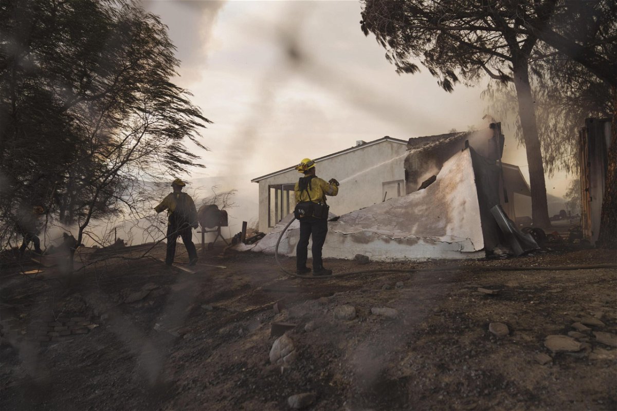 <i>Eric Thayer/Bloomberg/Getty Images</i><br/>Firefighters spray down a building during the Route Fire in Castaic