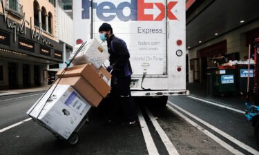 FedEx shares plunged 21% in premarket trading on September 16 after it warned that a slowing economy will cause it to fall $500 million short of its revenue target. A FedEx truck is pictured here making deliveries on December 6 in New York City.
