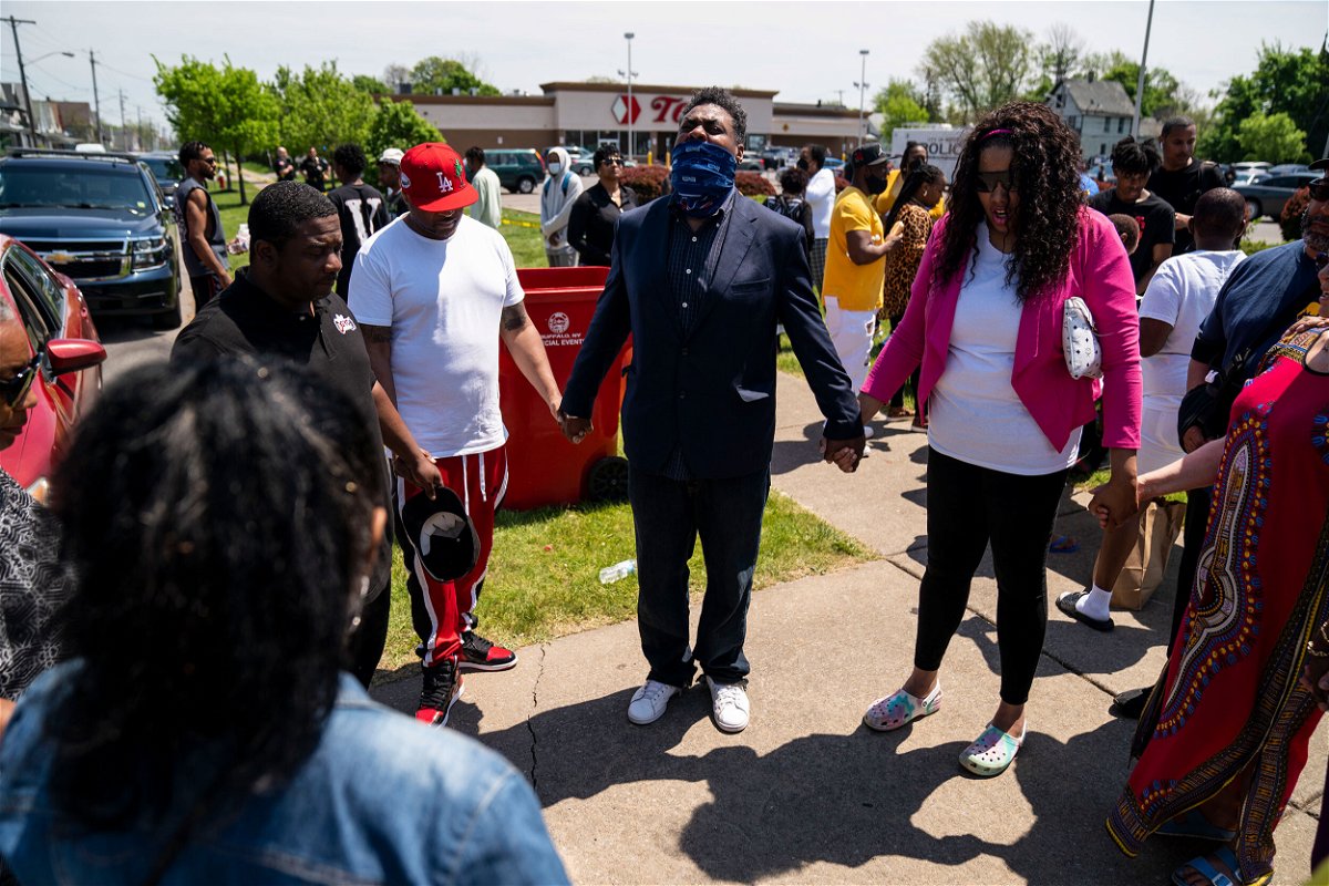 <i>Kent Nishimura/Los Angeles Times/Getty Images</i><br/>A prayer circle formed outside the Tops supermarket in Buffalo on Sunday