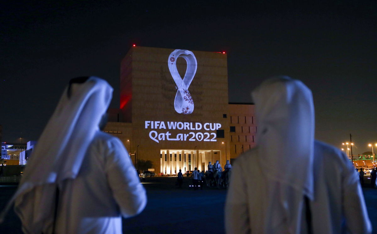 <i>-/AFP/AFP via Getty Images</i><br/>Qataris gather at Doha's traditional Souq Waqif market as the official logo of the 2022 World Cup is projected on a building in September 2019.