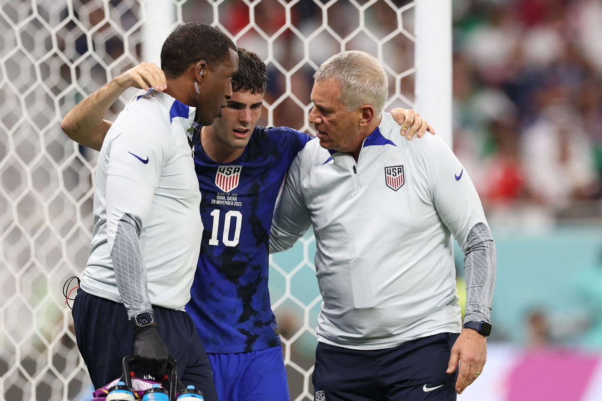 <i>FADEL SENNA/AFP/AFP via Getty Images</i><br/>Christian Pulisic is helped off the field on November 29.