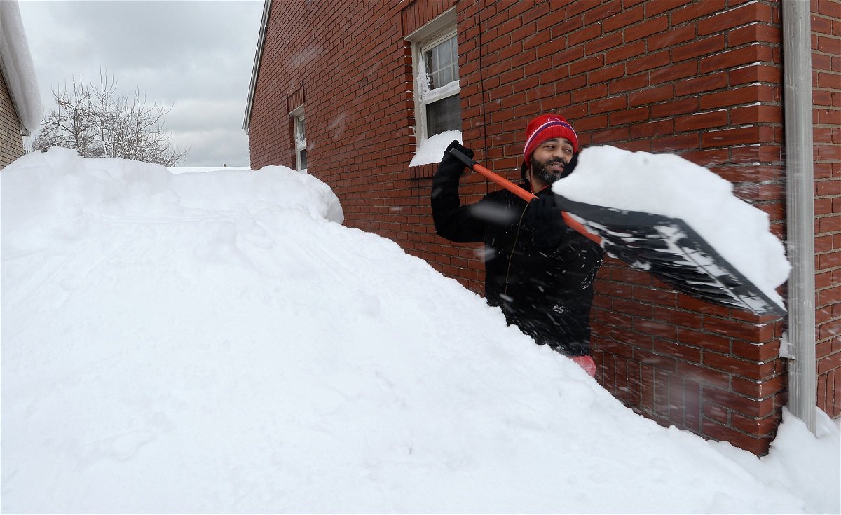 <i>Greg Wohlford/Erie Times-News/AP</i><br/>Patrick Harden clears snow from the roof of his car in Erie