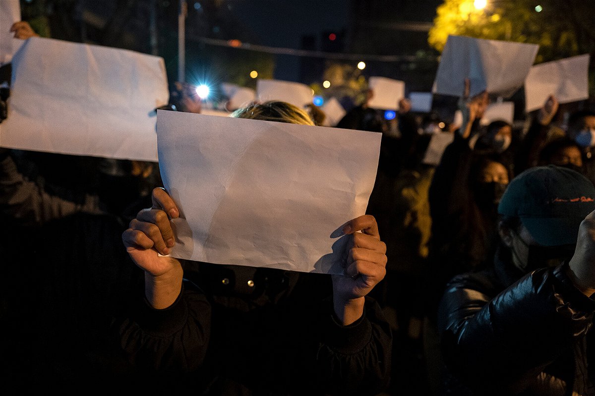 <i>Kevin Frayer/Getty Images</i><br/>Protesters hold up a white piece of paper against censorship as they march during a protest against China's strict Covid-19 measures on November 27