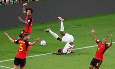 Canada's Richie Laryea in action after sustaining an injury as Belgium players react.