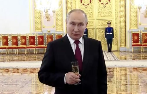 President Putin is pictured at the Kremlin reception while clutching a glass of champagne.
