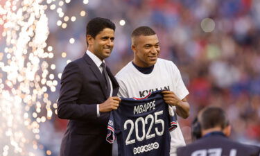 Paris St. Germain's Kylian Mbappe (right) poses for a photo with Paris St. Germain president Nasser Al-Khelaifi after signing a new contract on May 21.