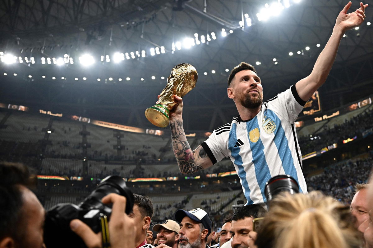 <i>Anne-Christine Poujoulat/AFP/Getty Images</i><br/>Argentina's captain and forward Lionel Messi holds the FIFA World Cup Trophy following the ceremony after Argentina won the Qatar 2022 World Cup final on December 18.