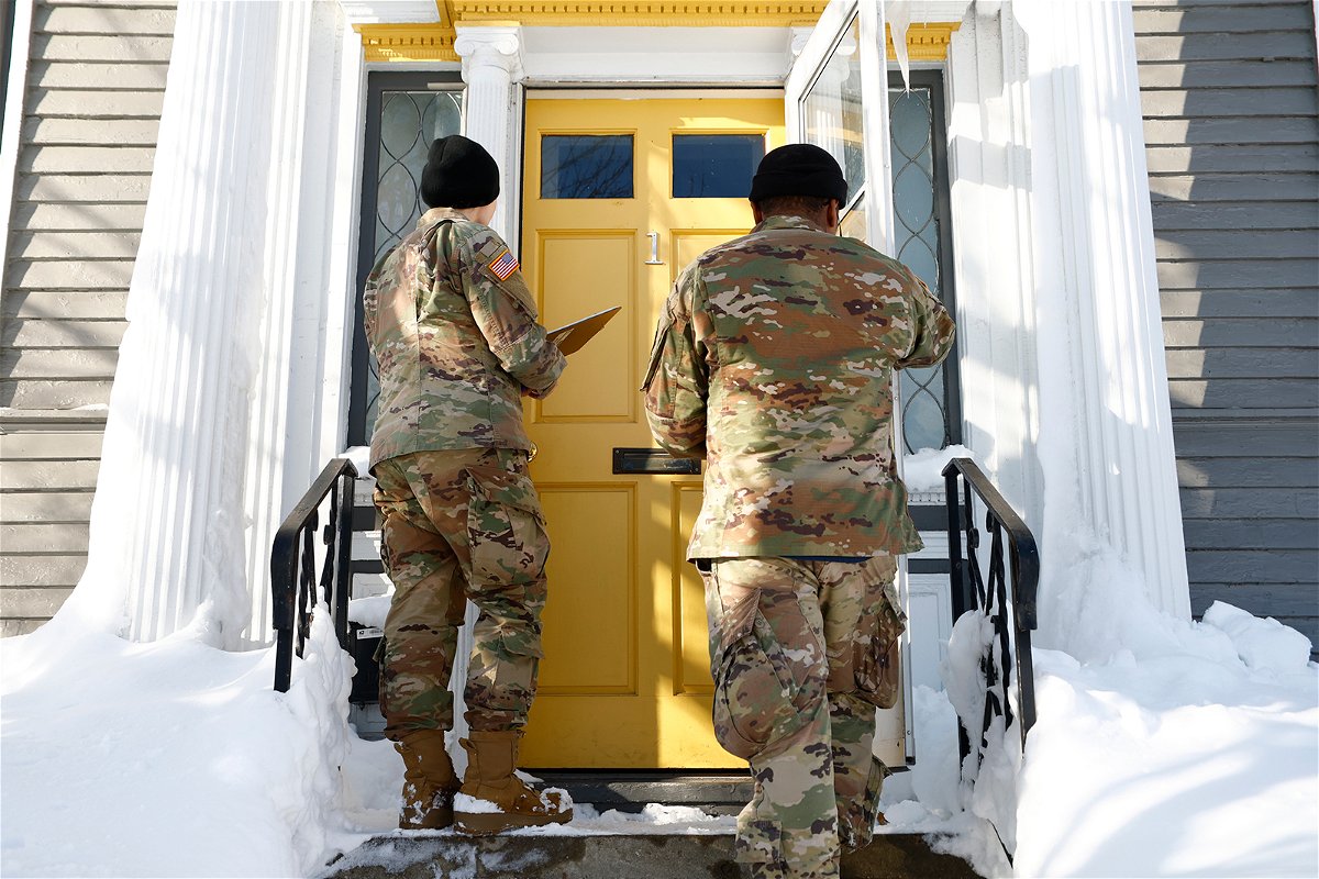 <i>Jeffrey T. Barnes/AP</i><br/>National guard members check on residents on December 28
