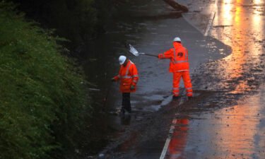 A crew works Tuesday to clear a flooded portion of California's northbound Highway 13 in Oakland.