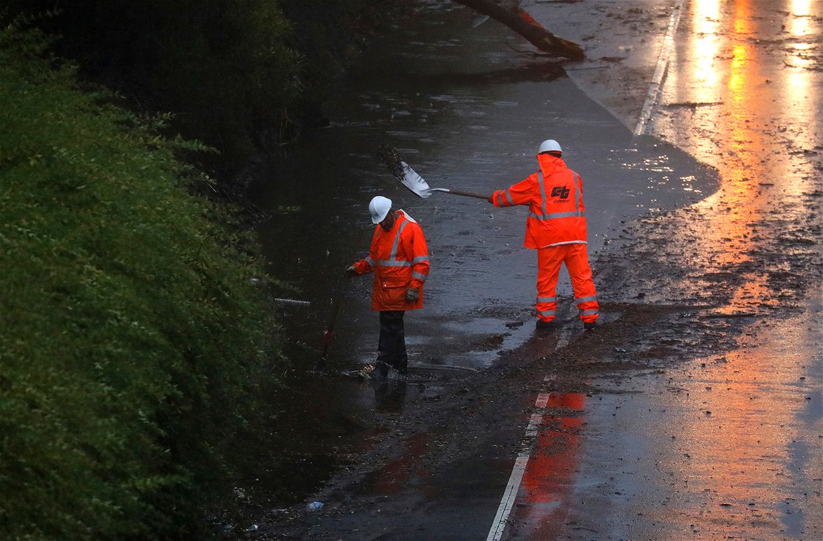 <i>Aric Crabb/AP</i><br/>A crew works Tuesday to clear a flooded portion of California's northbound Highway 13 in Oakland.