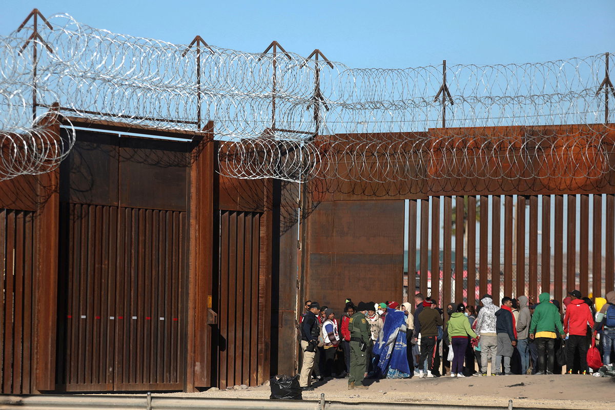 <i>Herika Martinez/AFP/Getty Images</i><br/>Migrants queue at the border wall to be received by Border Patrol agents after crossing the Rio Bravo river.