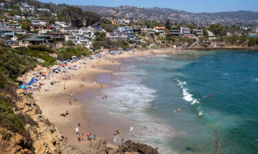 Beach-goers take to the waves at Crescent Bay Beach in July of 2020.