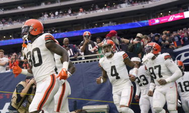 Watson runs onto the field with his team for the game against the Texans.