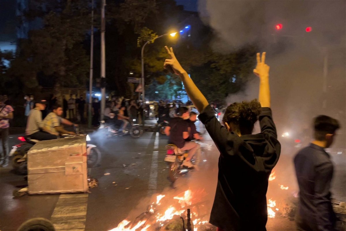 A demonstrator raises his arms and makes the victory sign during a protest in Tehran on September 19