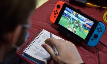 A competitor makes notes while playing Pokemon on a Nintendo Switch console during the 2022 Pokémon World Championships on August 18
