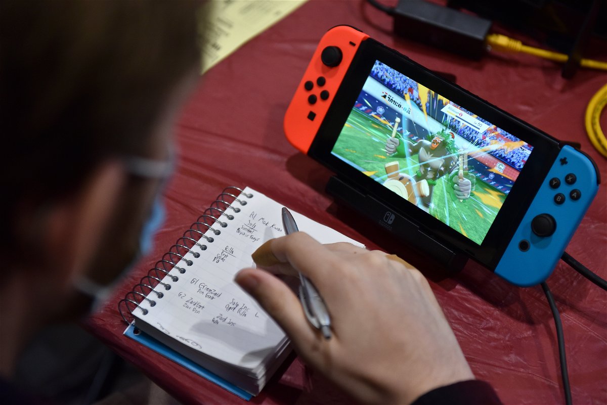 A competitor makes notes while playing Pokemon on a Nintendo Switch console during the 2022 Pokémon World Championships on August 18