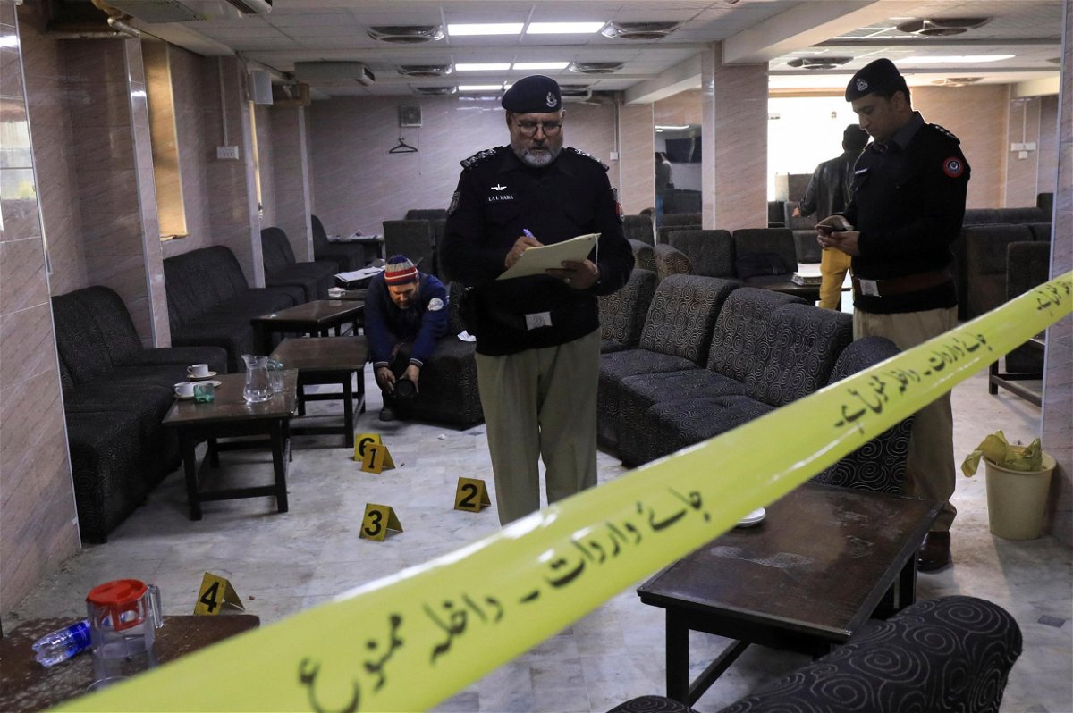 Police officers survey the crime scene following the shooting at Pakistan's High Court that resulted in the death of prominent lawyer Abdul Latif Afridi.
