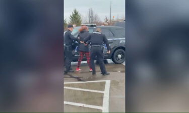 Two Ohio police officers are under investigation after a bystander video shows one officer punching a woman in the face outside a McDonald's.