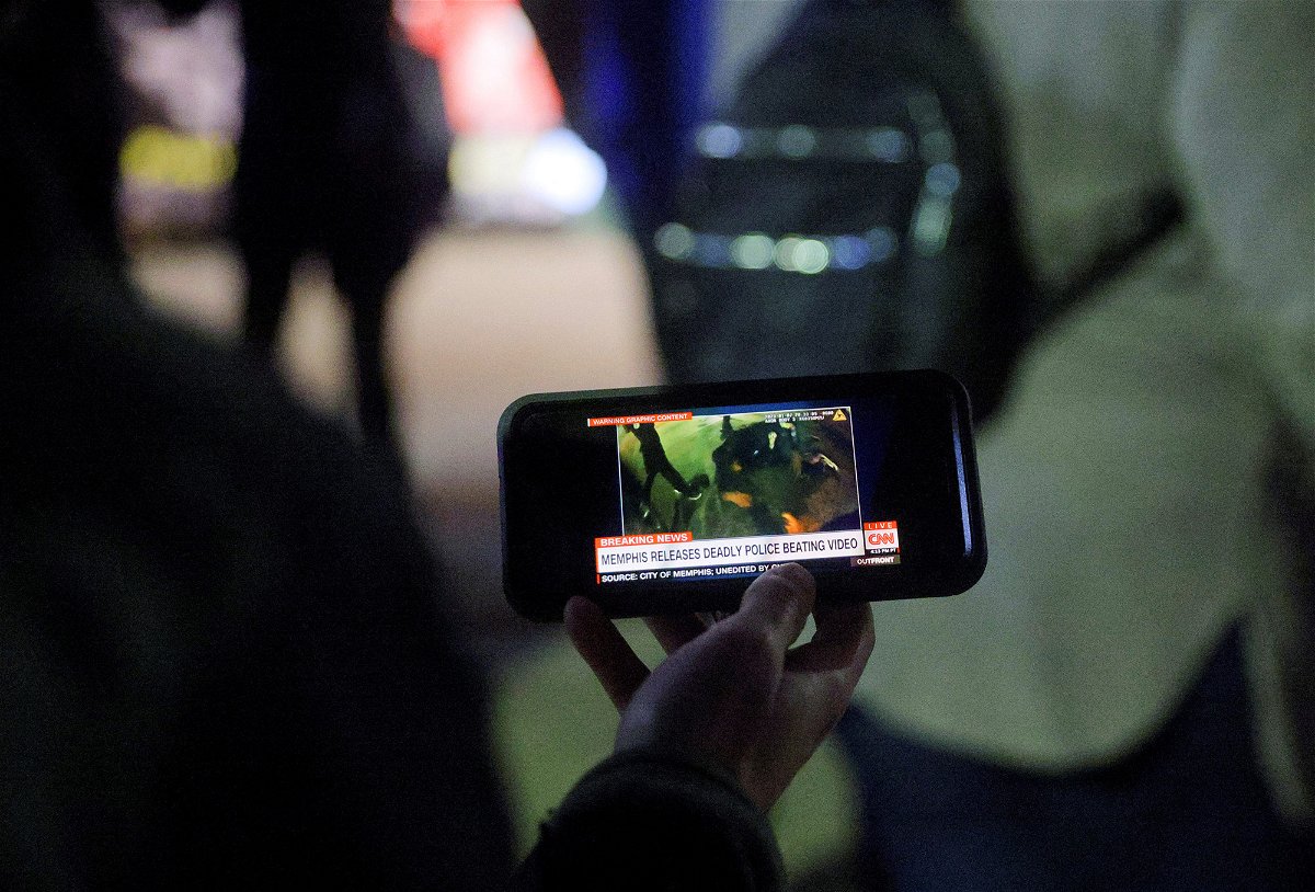 A protestor watches a video showing the Memphis police beating of Tyre Nichols