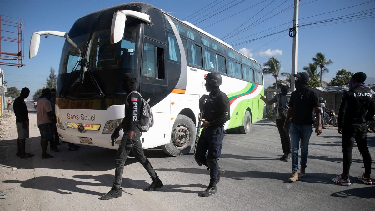 <i>Odelyn Joseph/AP</i><br/>Masked officers force a driver to park his bus to be used as a barricade during a protest to denounce bad police governance
