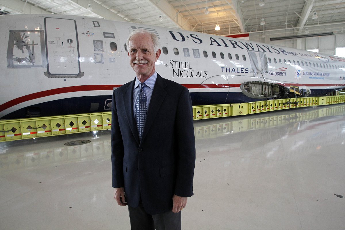 Captain Chesley "Sully" Sullenberger poses in front of the "Miracle on the Hudson" plane.