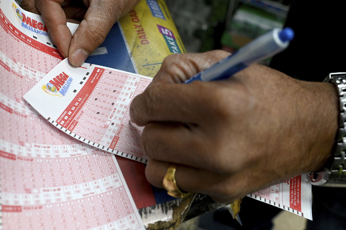 <i>Anthony Behar/SIPA/AP</i><br/>A man fills out a Mega Millions form playing for the Mega Million jackpot estimated at $1.35 Billion