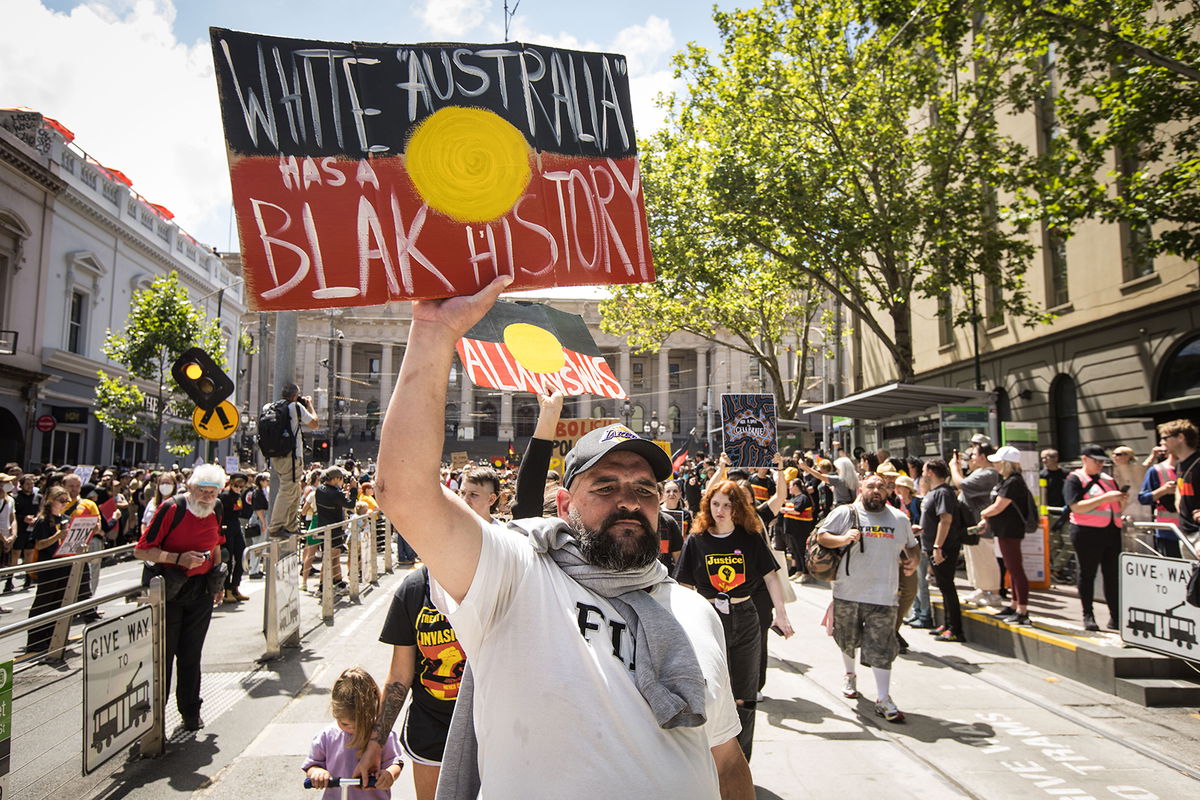 People march down Bourke street during the Invasion Day rally on January 26 in Melbourne