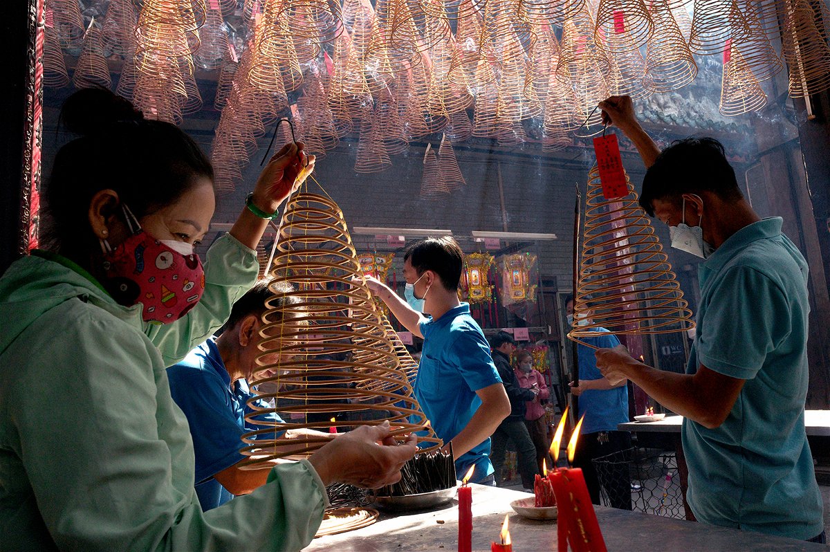People pray over incense at Thien Hau Pagoda for the Tet Lunar New Year on January 24 in Ho Chi Minh City