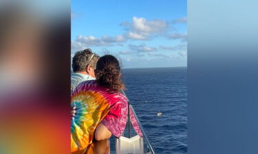 A boat of migrants is seen from an upper deck of the Celebrity Beyond cruise ship.