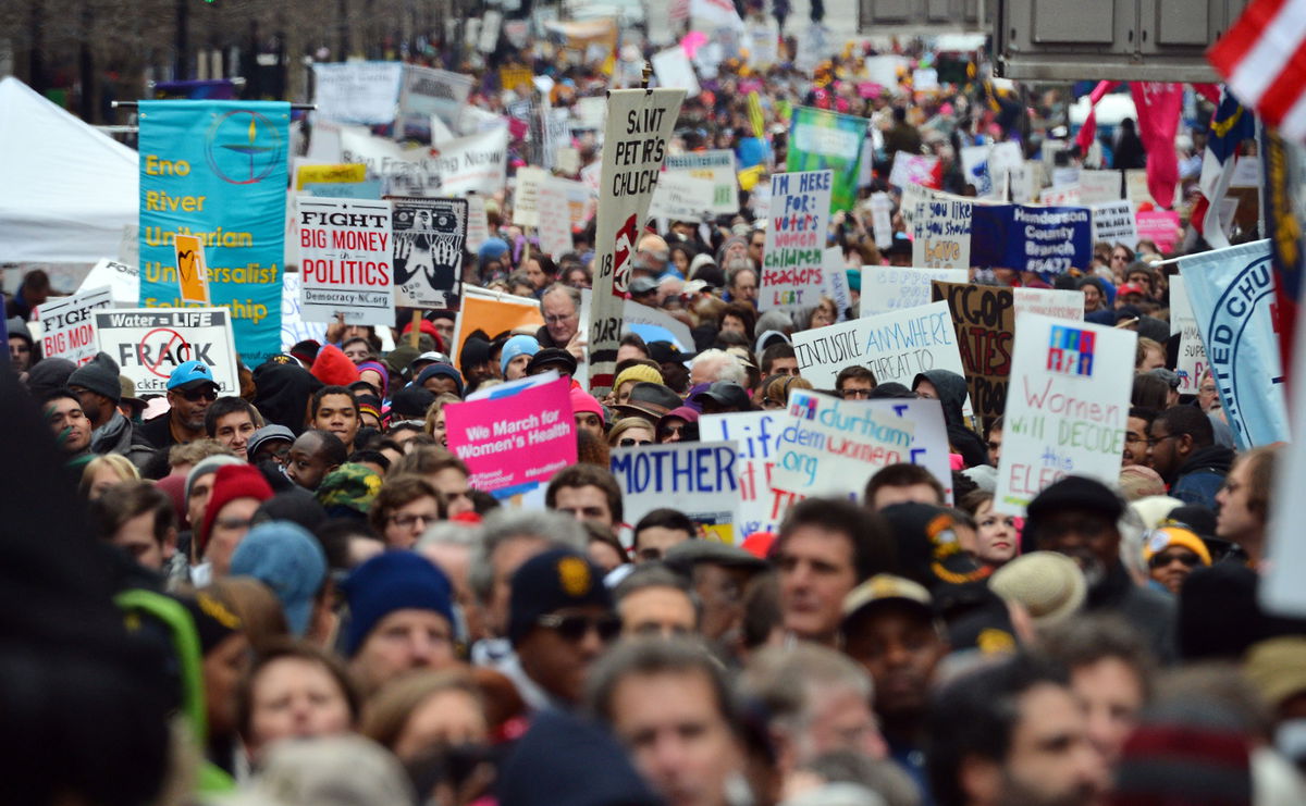 <i>Chuck Liddy/The News & Observer/AP</i><br/>Thousands of people march through through downtown Raleigh