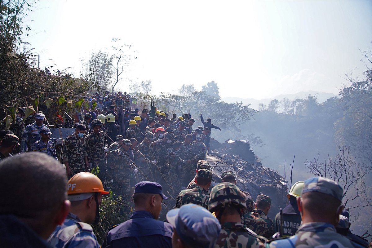 Rescuers gather at the site of a plane crash in Pokhara.