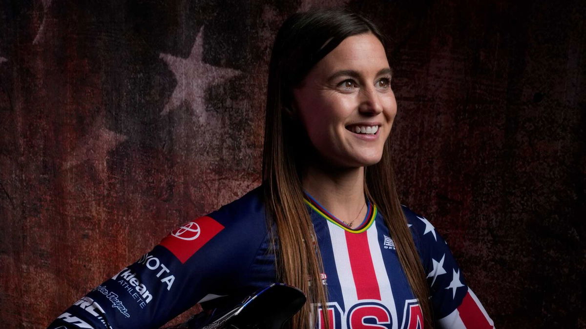 Alise Willoughby poses in front of American flag backdrop