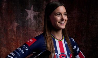 Alise Willoughby poses in front of American flag backdrop