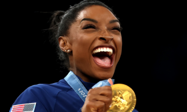 Simone Biles poses with her gold medal from the team final at the 2024 Paris Olympics.