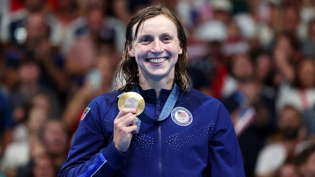 Katie Ledecky poses on the podium with her gold medal